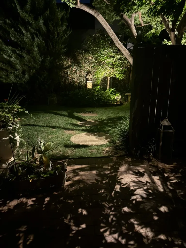 Garden path under lit trees. Landscape Lighting by LIT Outdoor Lighting in Tulsa.