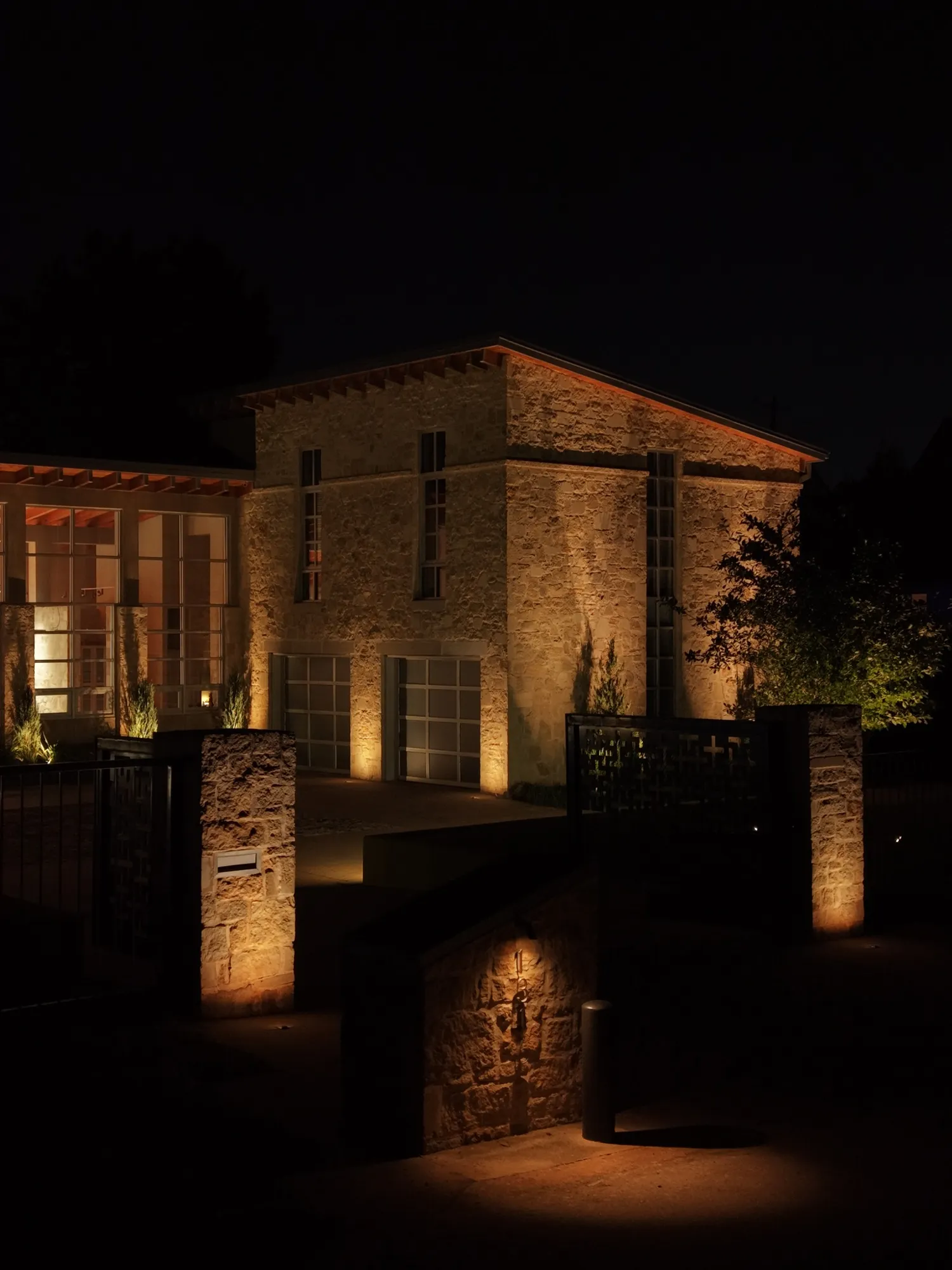 Stone house washed with warm light. Landscape Lighting by LIT Outdoor Lighting in Tulsa.