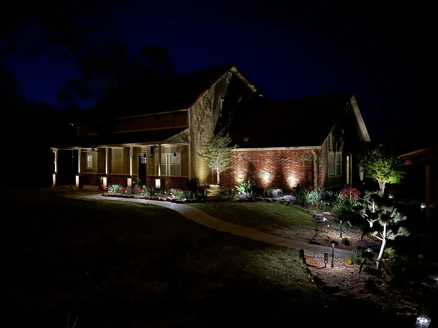 Uplit trees over a brick drive. Landscape Lighting by LIT Outdoor Lighting in Tulsa.