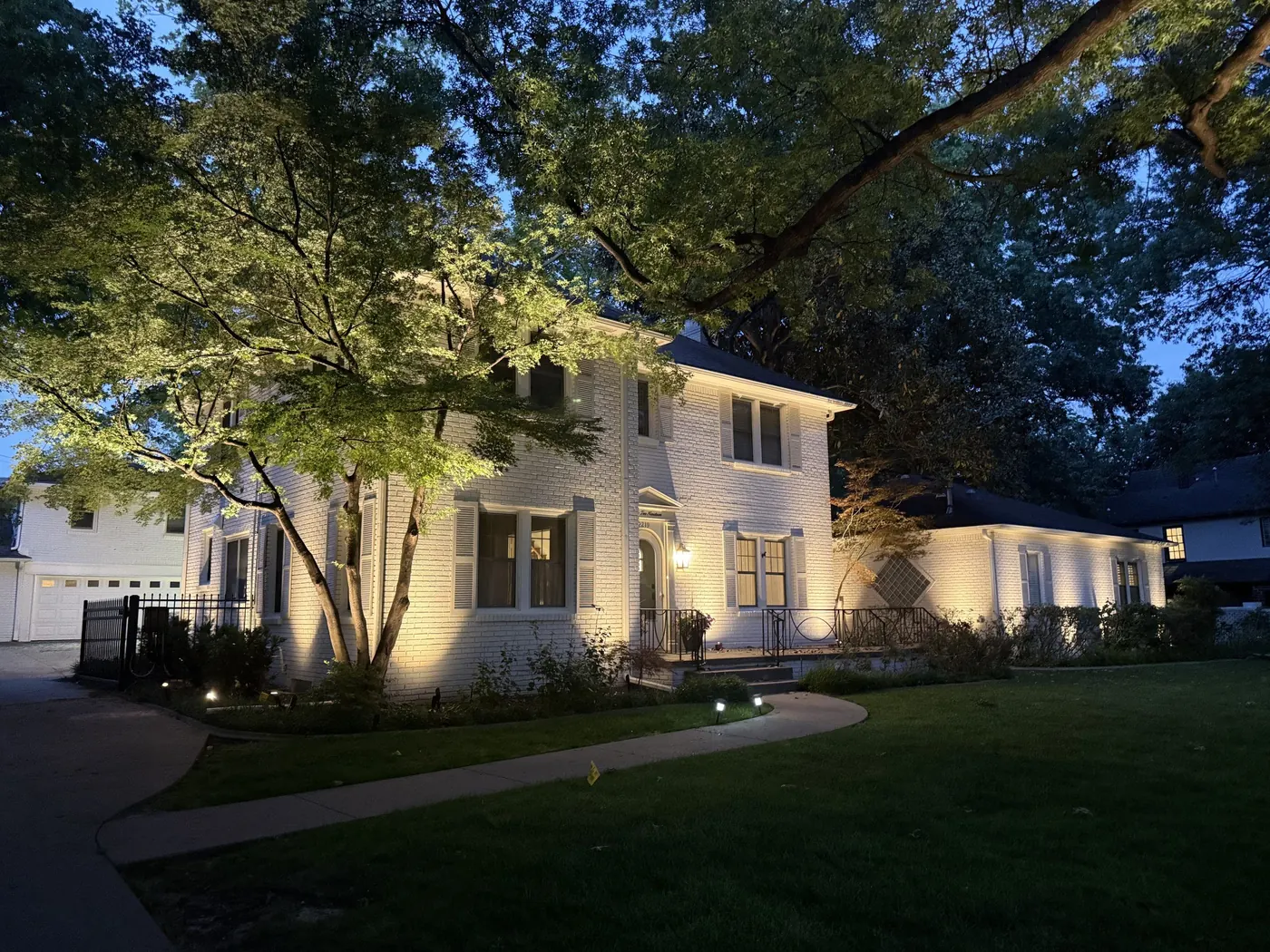 White brick two story, washed and uplit. Landscape Lighting by LIT Outdoor Lighting in Tulsa.