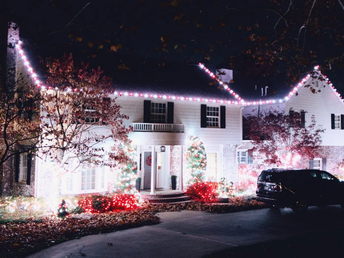 White colonial in red and white. Christmas Lighting by LIT Outdoor Lighting in Tulsa.